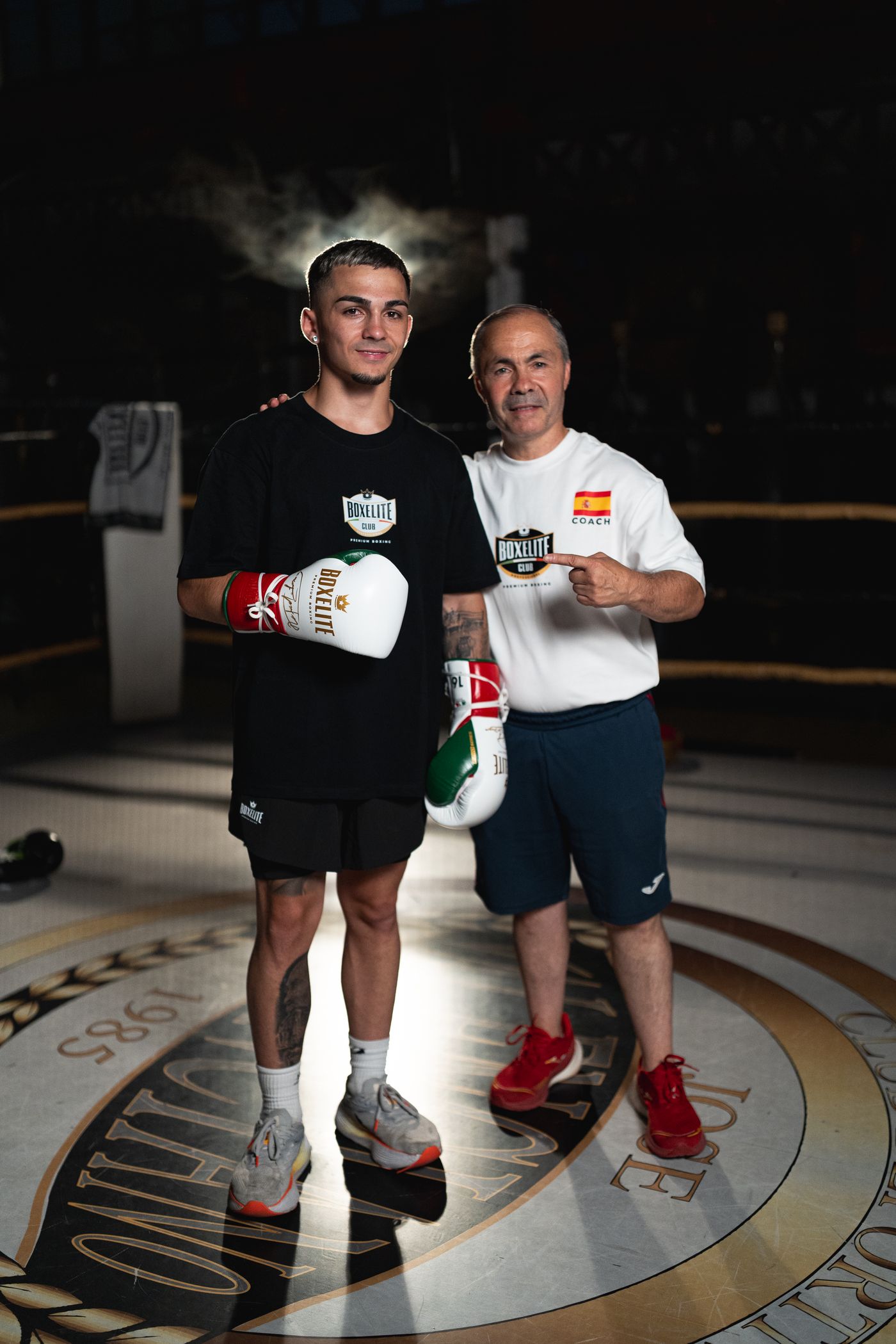 Rafael Lozano Sr, Spanish Olympic medallist and national team head coach, smiling in the ring with his son Rafael Lozano Jr who wears the BOXELITE S-PRO MX Tri-Color gloves
