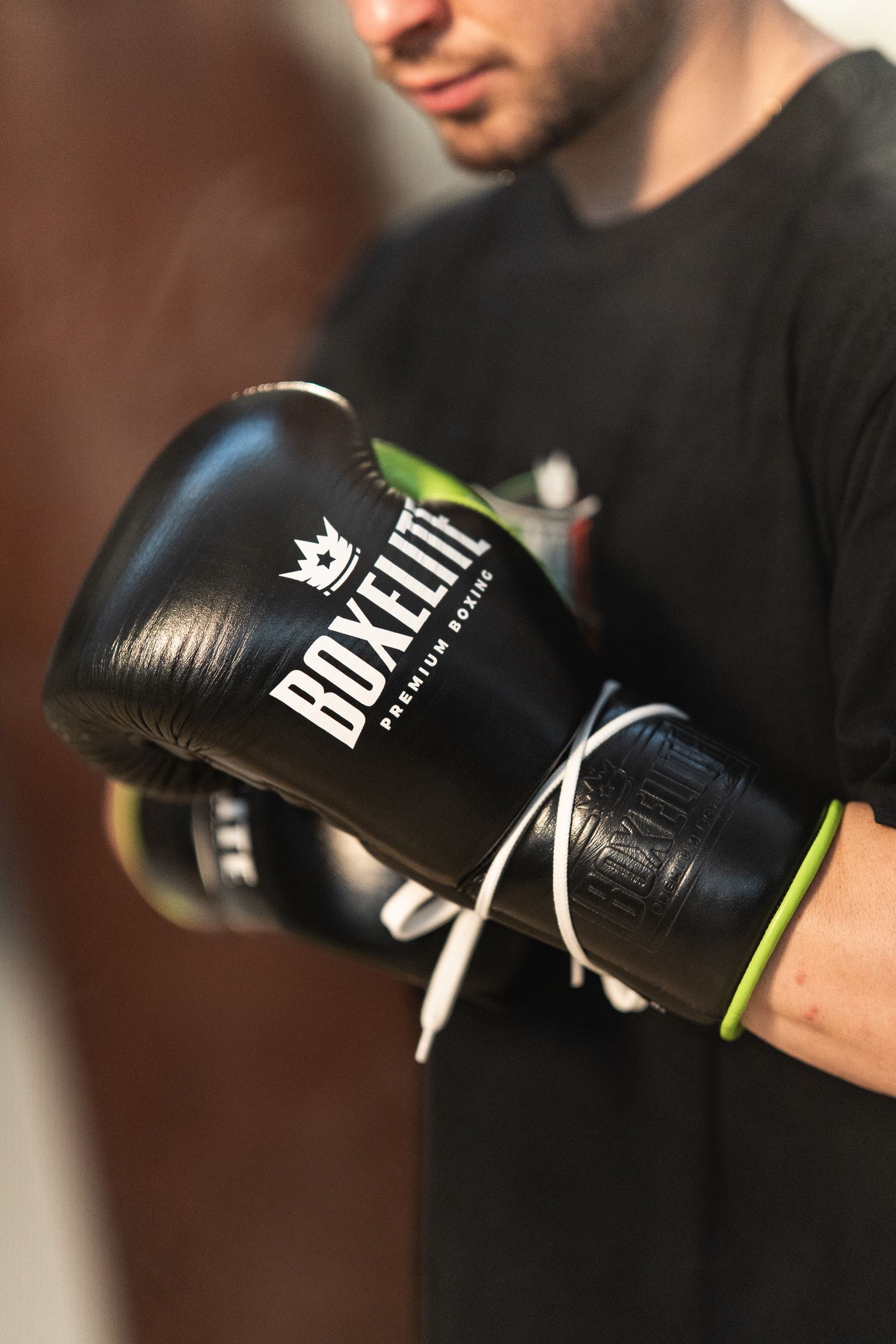 Close-up detail of the BOXELITE S-PRO Black and Neon boxing glove in premium cowhide leather with laces